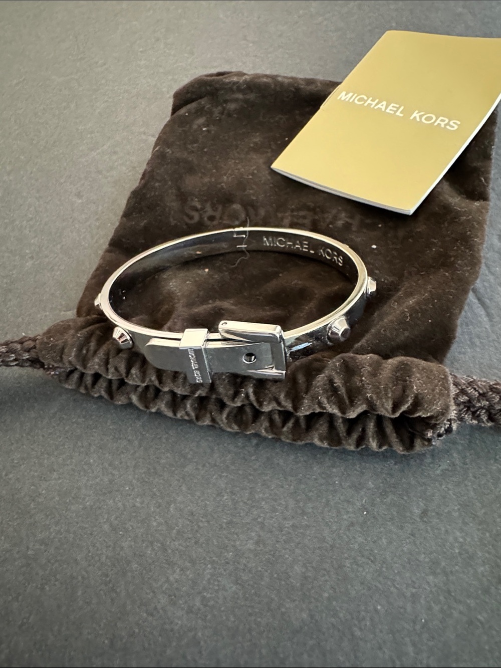 Michael Kors Silver Astor Buckle Bangle featuring a prominent belt buckle